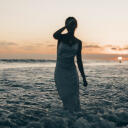 Modellbild på kvinna i vit klänning i havet