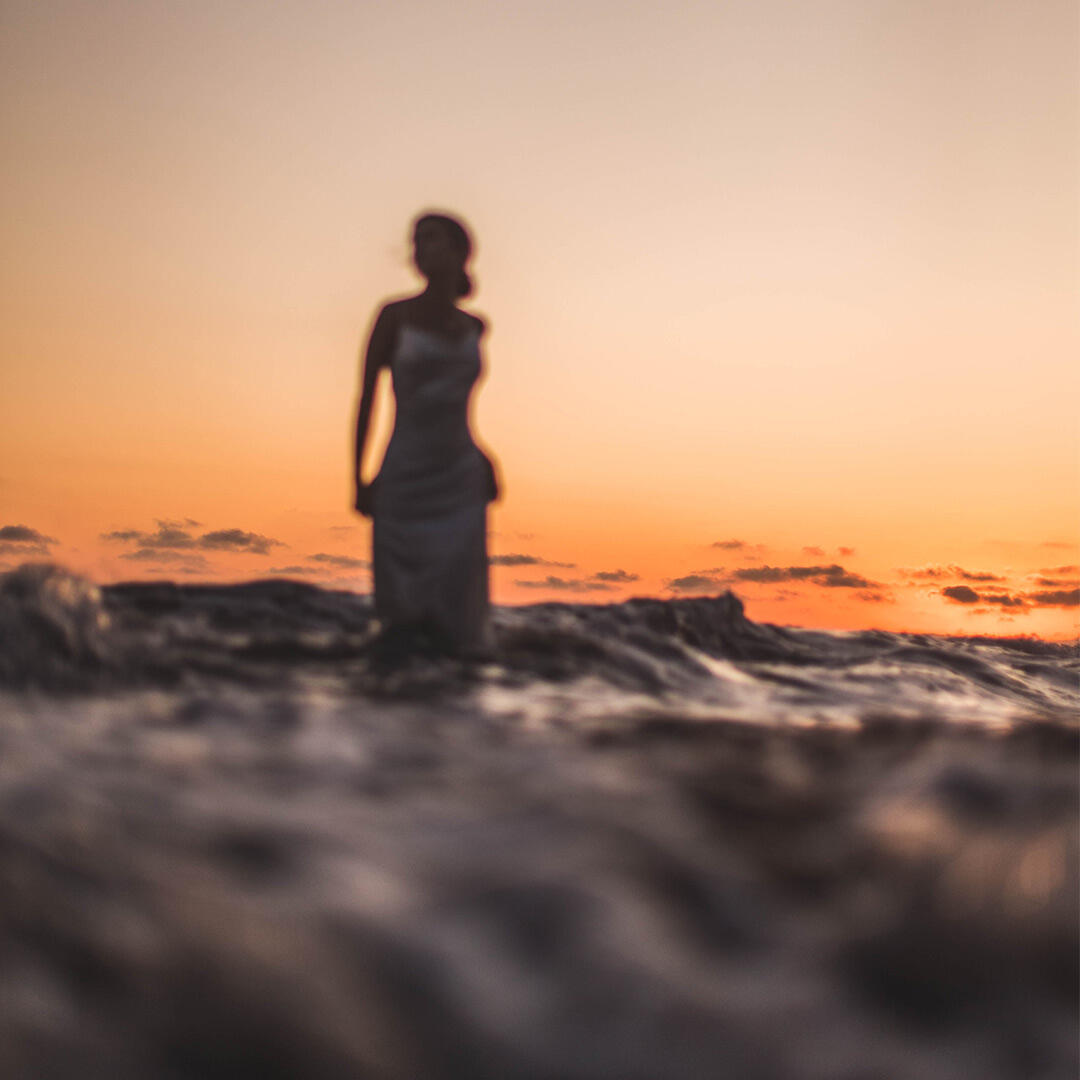 Suddig bild på modellkvinna med uppsatt hår i havet